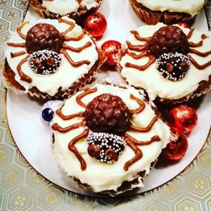 Cupcakes decorated with white frosting and a candy spider
